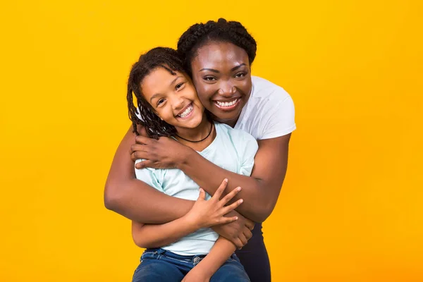 Black mother hugging with her smiling girl — Stock Photo, Image