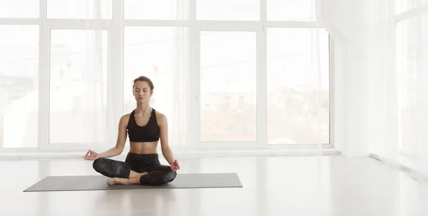 Ruhige Frau sitzt in Lotus-Pose und meditiert — Stockfoto