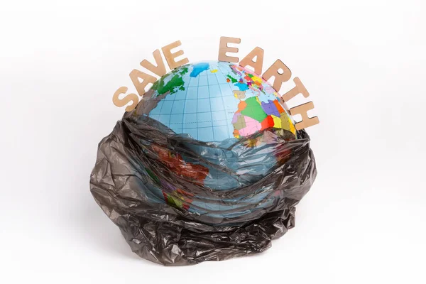 Sla de aarde tekst en bol in plastic zak geïsoleerd op wit — Stockfoto