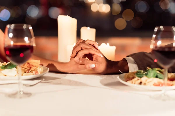 Uomo e donna che tengono le mani sul tavolo nel ristorante, primo piano — Foto Stock