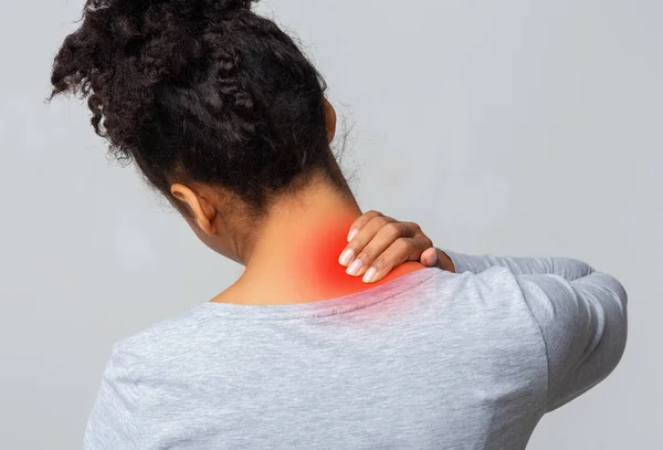 Mujer afro con dolor de cuello, vista de espalda — Foto de Stock