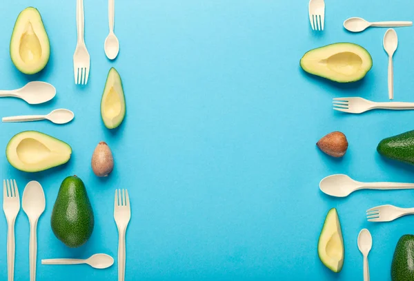 Gafflar och skedar av avokado frön kreativt mönster på blå — Stockfoto