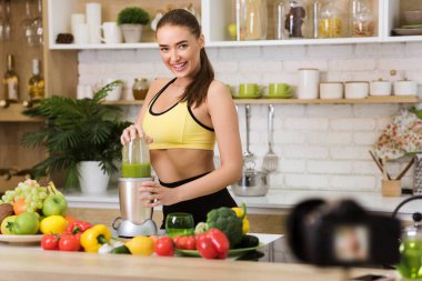 Spor blogcusu. Smoothie hazırlayan ve video kaydeden kız