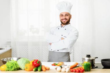 Üniformalı aşçı, restoran mutfağında el ele tutuşuyor.