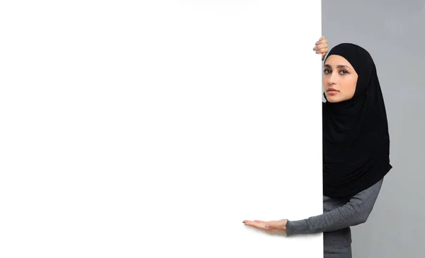 Mujer islámica seria secuestrada que señala a la junta de anuncios en blanco. — Foto de Stock