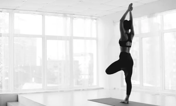 Sportliche Frau praktiziert Yoga in Baumpose — Stockfoto