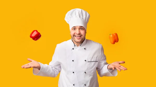 Chef Guy házet sladké papriky ve vzduchu, žluté pozadí, Panorama — Stock fotografie