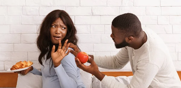 Man smekend zijn zwangere vrouw eet fruit — Stockfoto
