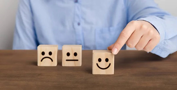 Klant drukt smiley face emoticon op houten kubus — Stockfoto