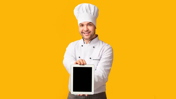 Chef Man Wyświetlanie Tablet pusty ekran stojący, żółte tło, Panorama — Zdjęcie stockowe