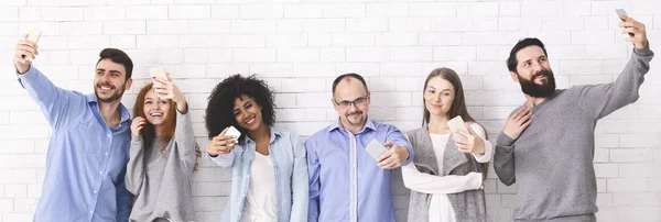 Grupo de millennials haciendo autorretratos usando teléfonos celulares — Foto de Stock