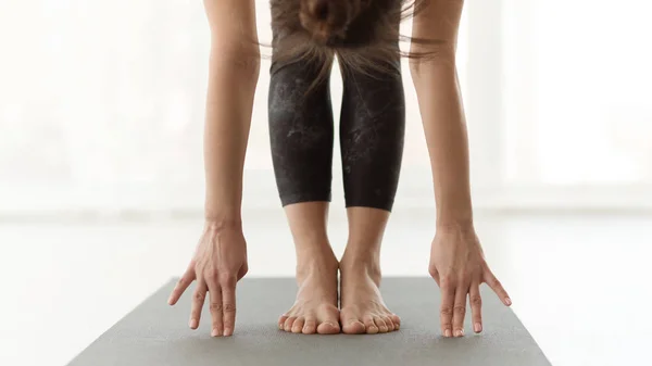 Jonge yogi vrouw die yoga beoefent, handen om teet pose — Stockfoto