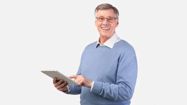 Hombre anciano sonriente usando tableta digital de pie, plano de estudio, panorámica —  Fotos de Stock