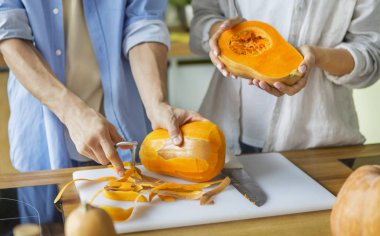 Tanınmayan bir çift taze balkabağından sağlıklı yemekler pişiriyor.