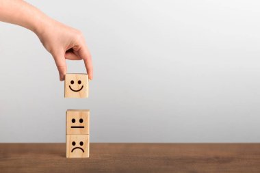 Hand picked up the happy face smile symbol on wooden cube