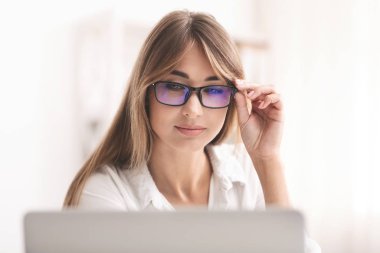 Lady In Eyeglasses Squinting Eyes Looking At Laptop In Office