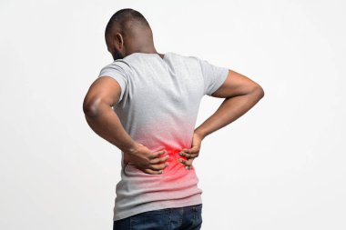Black man holding his hands on lower back