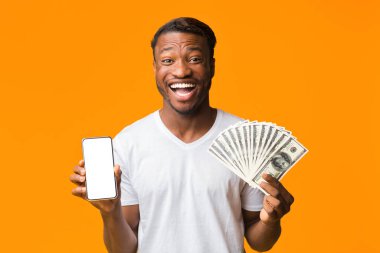 Excited Black Man Holding Smartphone And Money On Orange Background