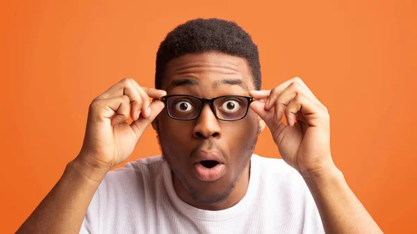 Surprised african american guy touching his eyewear — Stock Photo, Image