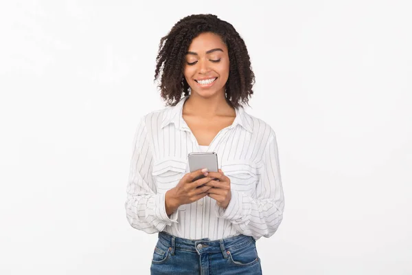 Smiling afro girl reading message from friend — 스톡 사진