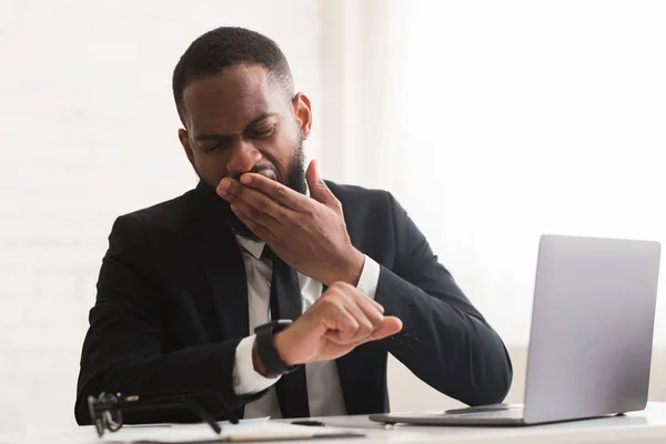 Empresario cansado bostezando y mirando el reloj —  Fotos de Stock