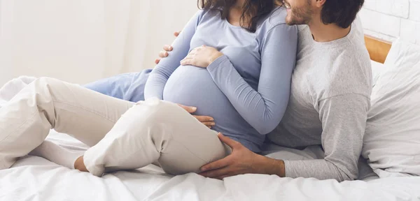 Coppia incinta rilassante sul letto a casa — Foto Stock
