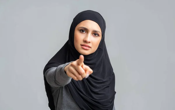 Занепокоєна арабська дівчина в окулярах вказує пальцем на камеру, звинувачуючи когось — стокове фото