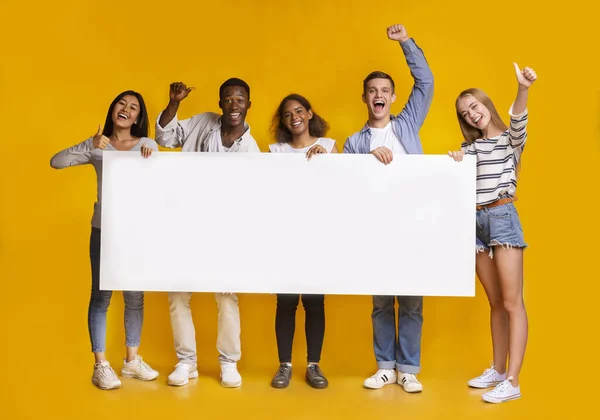 Happy smiling group of students standing together with white placard — Stock Photo, Image