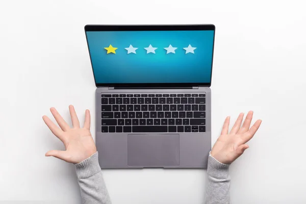 Woman wondering about lowest rating on screen of laptop — Stock Photo, Image