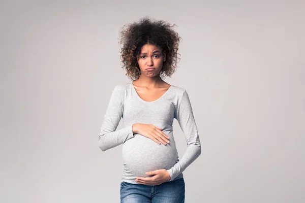 Ormoni e cambiamenti d'umore. Triste donna incinta che tocca la pancia — Foto Stock