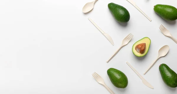 Avocados and disposable spoons isolated on white background — Stockfoto