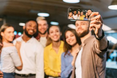Happy colleagues making selfie. Casual business team taking collective photo