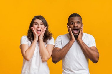 Hayretler içinde kameraya bakan ırklar arası bir çift.