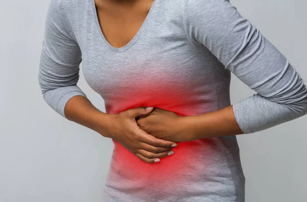 Mujer con dolor abdominal sobre fondo gris —  Fotos de Stock