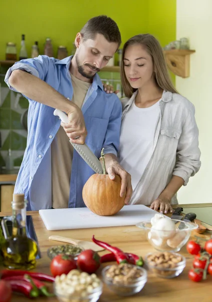 Young vegan couple cooking healthy food in the kitchen — Stockfoto