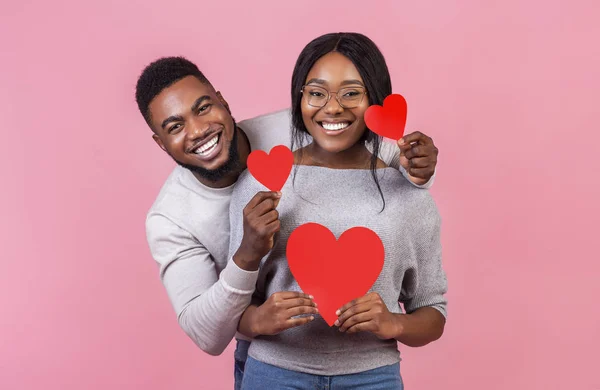 Alegre pareja afro sosteniendo tarjetas rojas de San Valentín — Foto de Stock