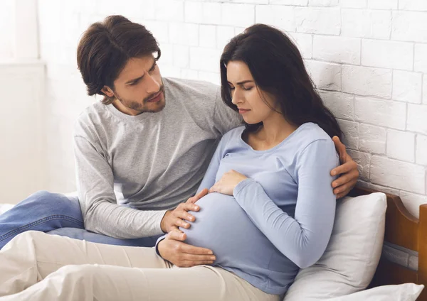 Besorgter Ehemann umarmt seine schwangere Frau, die sich unwohl fühlt — Stockfoto
