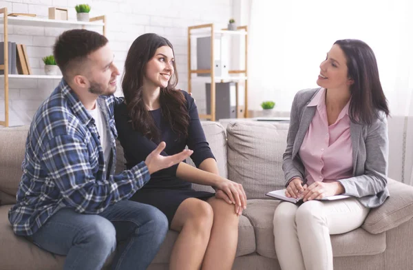 Young grateful spouses talking with marital counselor at office — Stock Photo, Image