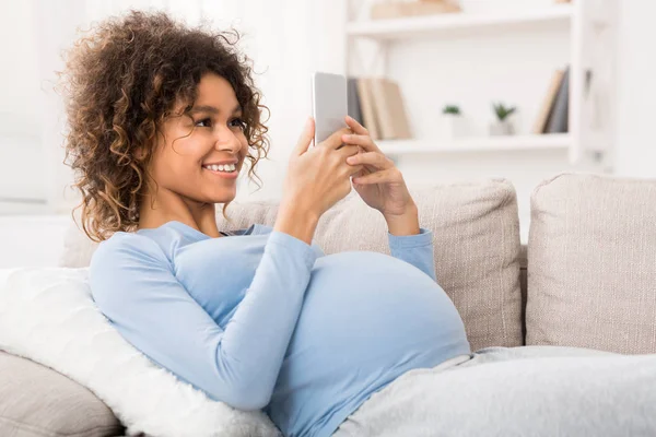 Afro-Amerikaanse zwangere vrouw browsen op smartphone, vrije ruimte — Stockfoto