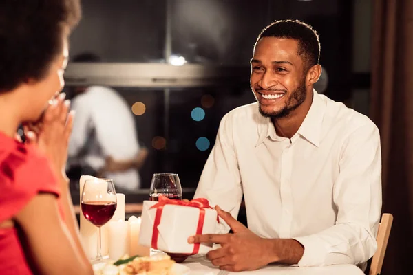 快乐的男人送礼给餐厅里的女朋友，有选择性的关注 — 图库照片
