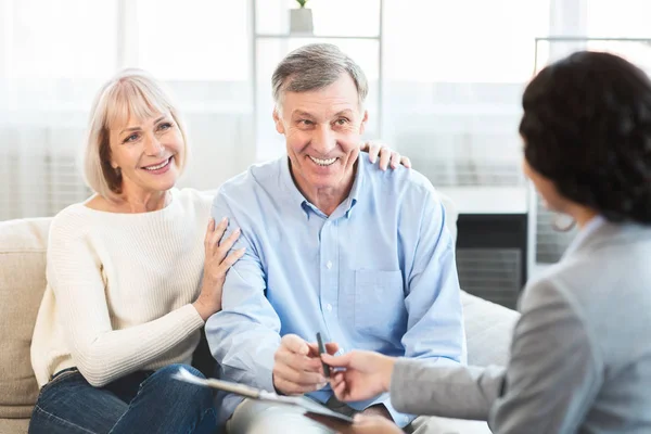 Szczęśliwa dojrzała para rozmawia z doradcą finansowym w domu — Zdjęcie stockowe