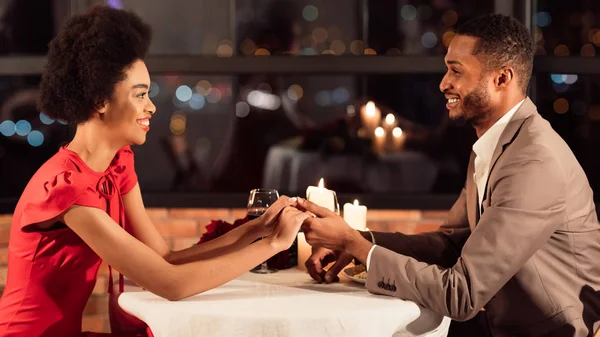 I coniugi afroamericani che tengono le mani mentre cenano nel ristorante, Panorama — Foto Stock