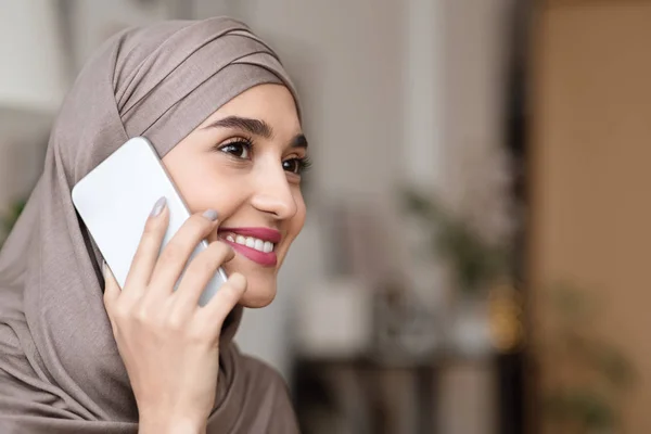 Portrait of modern muslim girl in hijab talking on cellphone indoors — Stok Foto