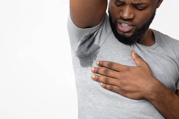 Afro guy disgusted by bad odor, smelling armpit — Stock Photo, Image