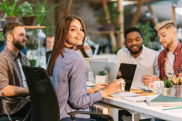 Lächelnder Webdesigner, der am Laptop arbeitet und in die Kamera schaut — Stockfoto