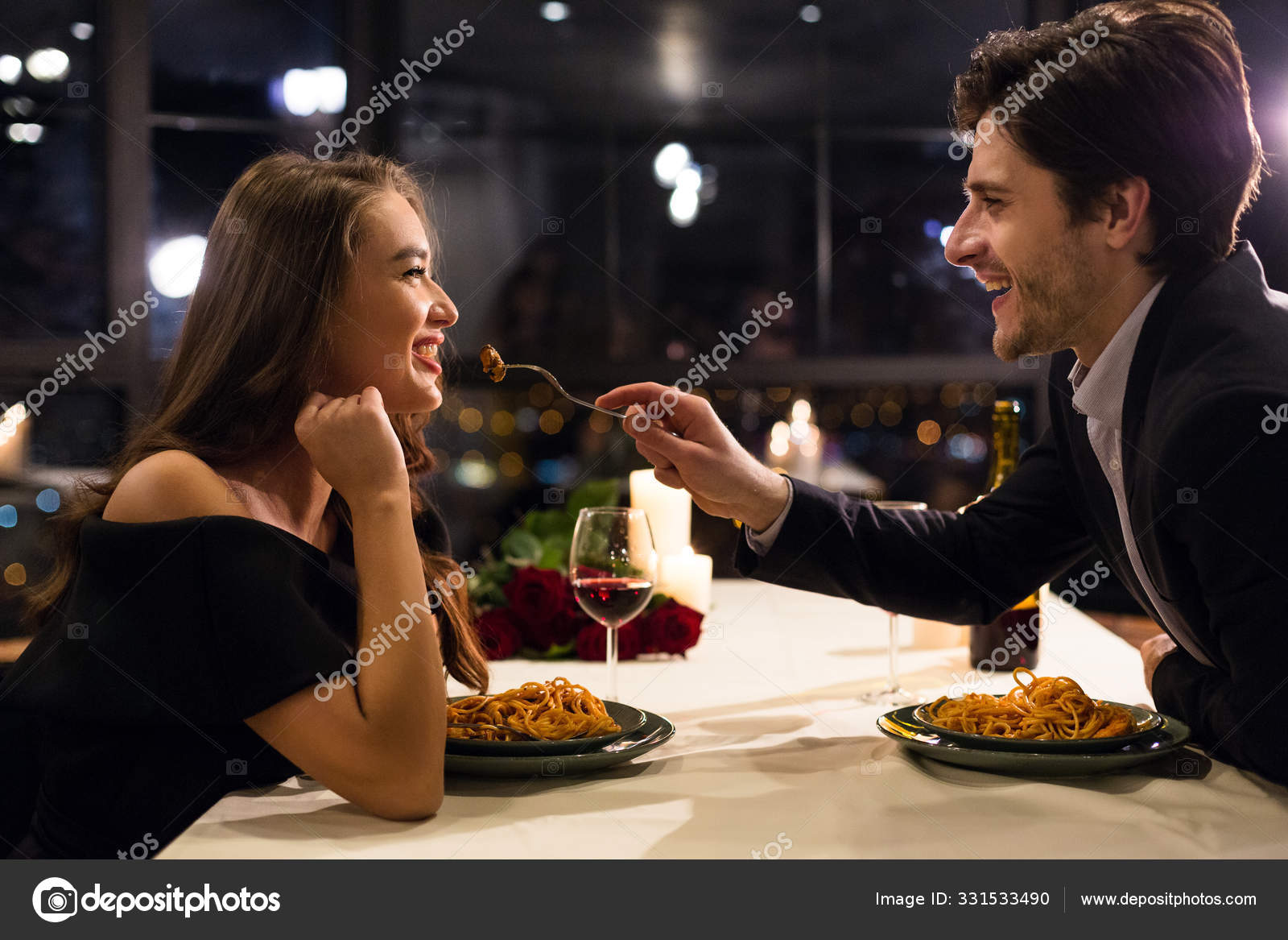 Hombre alegre alimentando a su novia en una cita romántica — Foto