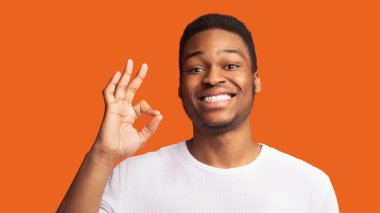 Mutlu siyahi adam işaret ediyor ve gülümsüyor.