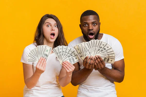 Impresionante pareja interracial sosteniendo mucho dinero en efectivo en las manos —  Fotos de Stock