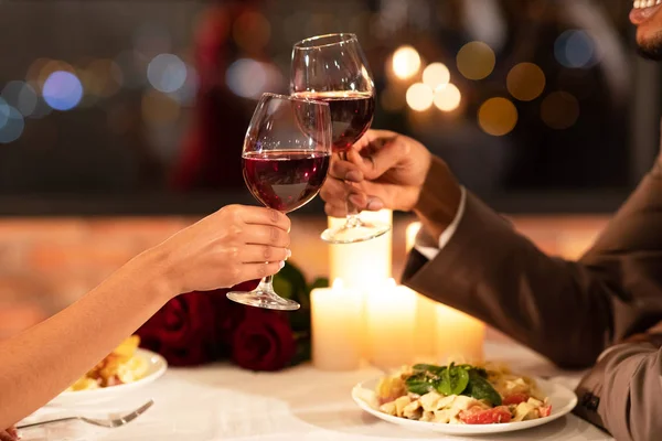 Parejas manos tintineando copas de vino tinto Citas En Restaurante —  Fotos de Stock