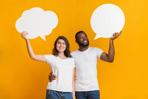 Pensive interracial couple holding empty speech bubbles above their heads — Stock Photo, Image